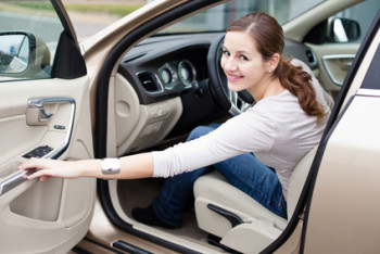 Pretty young woman driving her new car